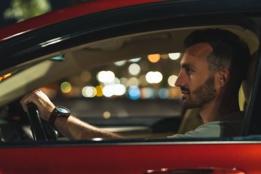 Çekici adam arabada oturuyor.