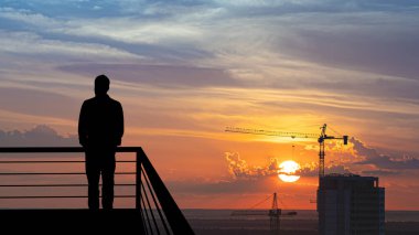 Binanın arka tarafındaki balkonda duran adam.