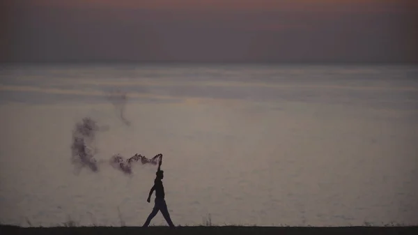 Pria Dengan Tongkat Asap Berjalan Sepanjang Garis Pantai — Stok Foto