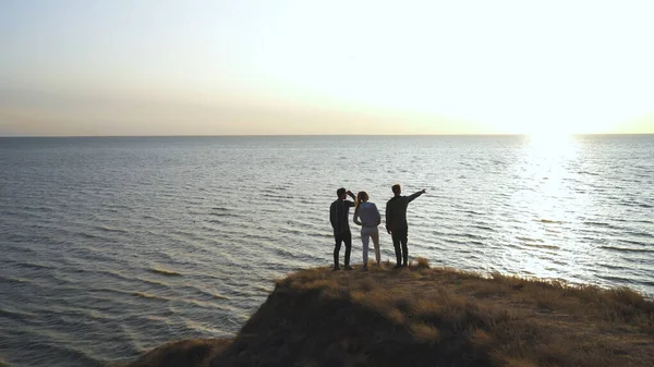Kolme Ihmistä Seisomassa Kalliolla Lähellä Merta — kuvapankkivalokuva