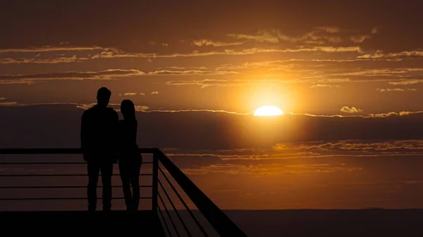 Romanttinen Pari Seisoo Parvekkeella Kauniilla Auringonlaskun Taustalla — kuvapankkivalokuva