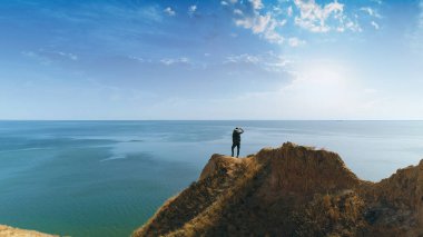 Dağda duran yürüyüşçü resimli deniz manzarasına karşı