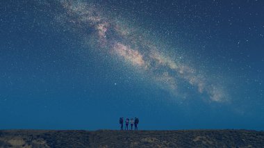 Yıldızlı gökyüzünde duran bir grup yürüyüşçü