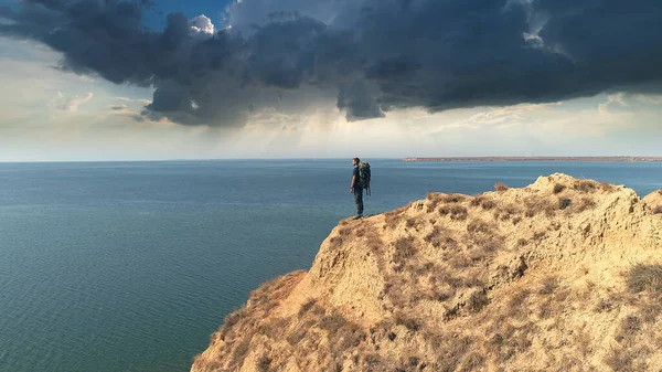 Mies Jolla Reppu Vuorella Sateisia Pilviä Vasten — kuvapankkivalokuva