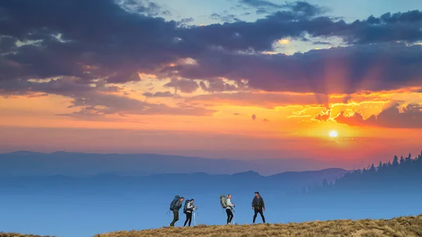 Quatro Pessoas Com Mochilas Andando Fundo Pôr Sol Montanha — Fotografia de Stock