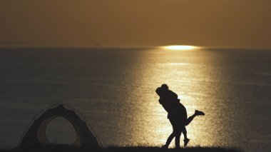 İki turist deniz kenarındaki kamp alanında duruyor.