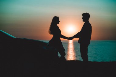 Güzel deniz arka planında el ele tutuşan adam ve kadın.
