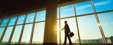 Ofiste elinde bavulla yürüyen adam.