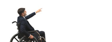 Tekerlekli sandalyedeki adam beyaz duvar arkasında el kol hareketi yapıyor.