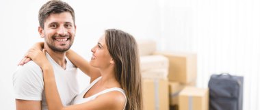 Adam kutuların arkasında bir kadına sarılıyor.