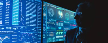 Karanlık odada mavi ekranın yanında duran adam.