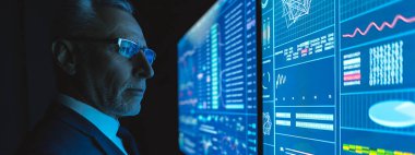 Karanlık odada mavi ekranın yanında duran adam.