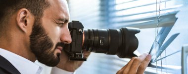 Panjurlarda fotoğraf çeken kameralı adam.