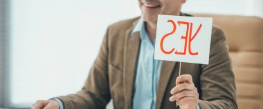 Plakalı bir işadamı ofisinde görüşme yapıyor.