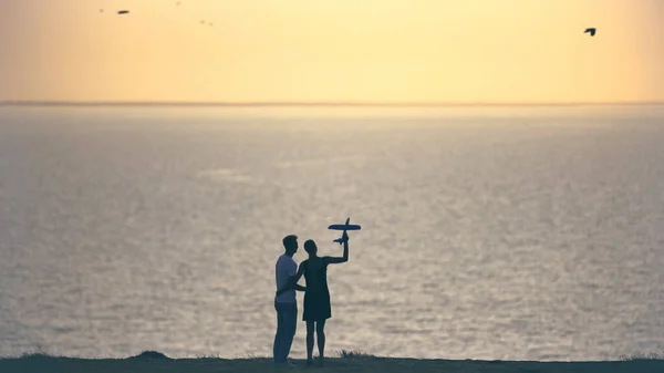 Mies Nainen Laukaisevat Lelukoneen Meren Rannalla — kuvapankkivalokuva