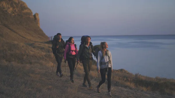 Empat Orang Dengan Ransel Berjalan Sepanjang Pantai Berbatu — Stok Foto