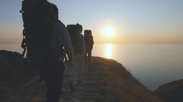 Matkailijat Reppuineen Kävelemässä Vuoristomaisemassa Lähellä Merta — kuvapankkivalokuva