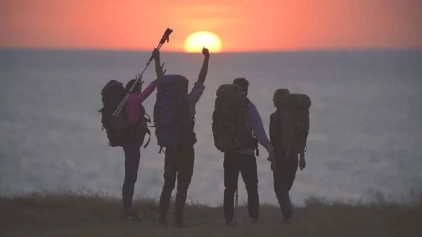 Neljä Turistia Seisoo Meren Rannalla Kauniilla Auringonlaskun Taustalla — kuvapankkivalokuva