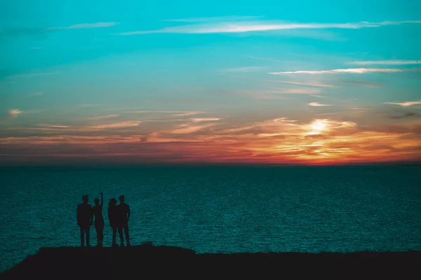 Empat Orang Berdiri Dekat Laut Pada Latar Belakang Langit Malam — Stok Foto