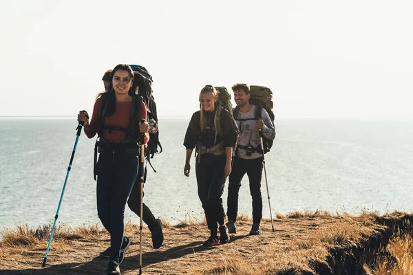 Empat Wisatawan Dengan Ransel Berjalan Sepanjang Pantai Laut — Stok Foto