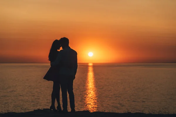 那对年轻夫妇站在海滨美丽的日落背景上 — 图库照片