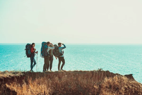 Los Cuatro Viajeros Con Mochilas Caminando Por Costa Del Mar — Foto de Stock