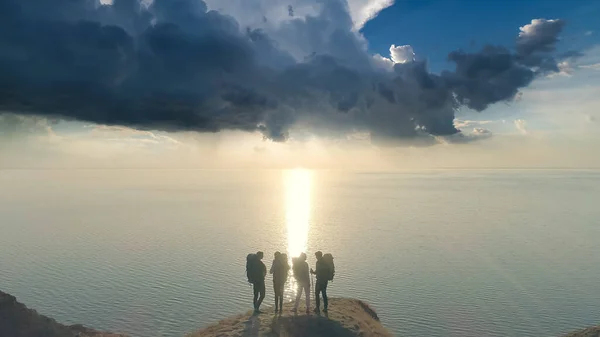 Die Vier Personen Die Auf Dem Berggipfel Gegen Das Meer — Stockfoto