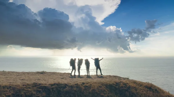 Keempat Pelancong Dengan Ransel Berdiri Latar Belakang Pemandangan Laut — Stok Foto