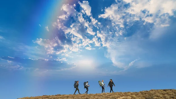 Четыре Путешественника Стоят Вершине Горы Против Красивого Неба — стоковое фото