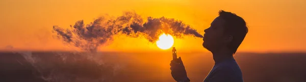 Der Mann Raucht Auf Dem Sonnenuntergang Eine Elektrische Zigarette — Stockfoto