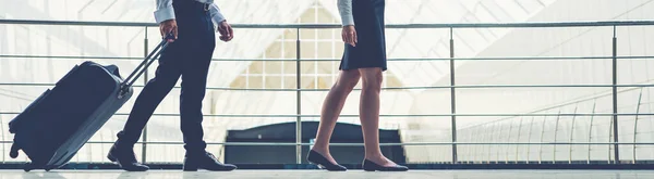 The happy business man and woman walk with a suitcase