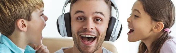 Padre Feliz Los Auriculares Jugando Con Niño Una Niña Mesa —  Fotos de Stock