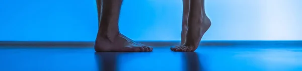 The legs of man and a woman near the bed. evening night time