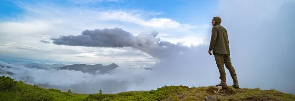 Mies Seisoo Vuorella Valkoisilla Pilvillä Taustalla — kuvapankkivalokuva