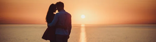 Romanttinen Pari Seisoo Lähellä Merta Kauniilla Auringonlaskun Taustalla — kuvapankkivalokuva