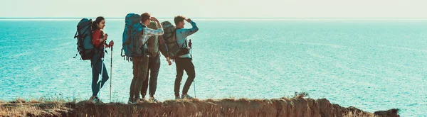 Keempat Wisatawan Dengan Ransel Berjalan Sepanjang Pantai Laut — Stok Foto