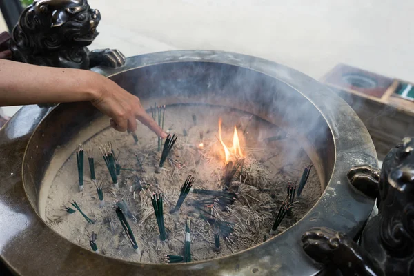 Incense burner and burning incense sticks.