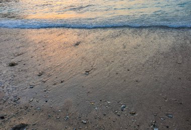 Endonezya, Bali 'deki Crystal Beach plajında gün batımında kumlar ve kayalar.