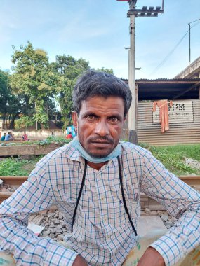 Dhaka, Bangladeş - 11.07.2021: Bangladeş 'te korona kilitlenirken bir demiryolunda oturan çaresiz zavallı adam. Bangladeş 'teki Corona kapanması sırasında kriz.
