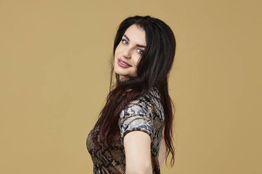 Stüdyoda sarı arka planda çekici bir esmer var.