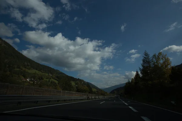 Yol, yeşil çayırlar, mavi gökyüzü — Stok fotoğraf