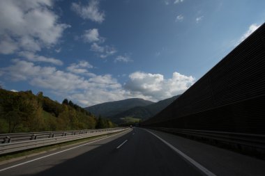 Yol, yeşil çayırlar, mavi gökyüzü