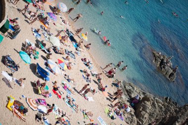 insanlar ve güneş şemsiyeleri sahilde