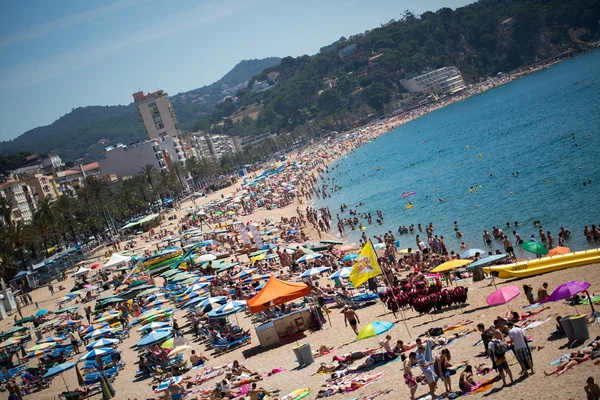 People and sun umbrellas on the beach — Stock Photo, Image