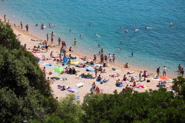 insanlar ve güneş şemsiyeleri sahilde