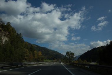 Yol, yeşil çayırlar, mavi gökyüzü