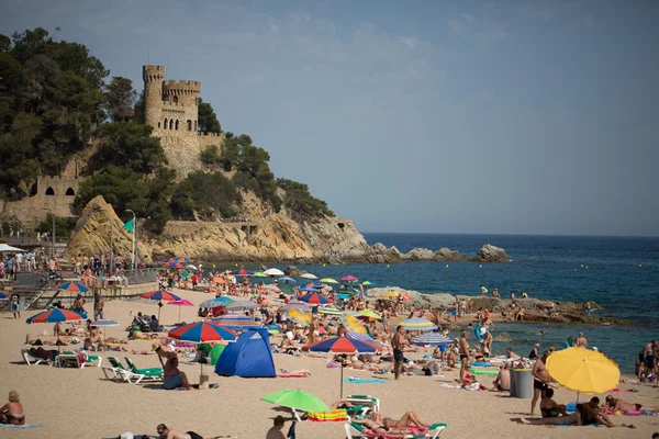 People and sun umbrellas on the beach — Stock Photo, Image