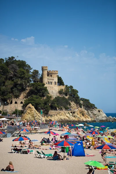 People and sun umbrellas on the beach — Stock Photo, Image