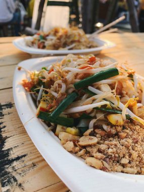 Yumurta, tofu ve sebzeli Pad Thai. Ahşap bir masada lezzetli geleneksel Asya sokak yemekleri.