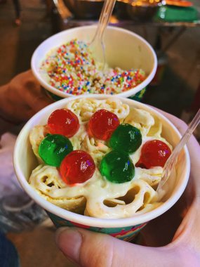 Kağıt kaselerde tatlı tatlı dondurması. Sokak yiyecek pazarında kaşıklı egzotik dondurmalar.